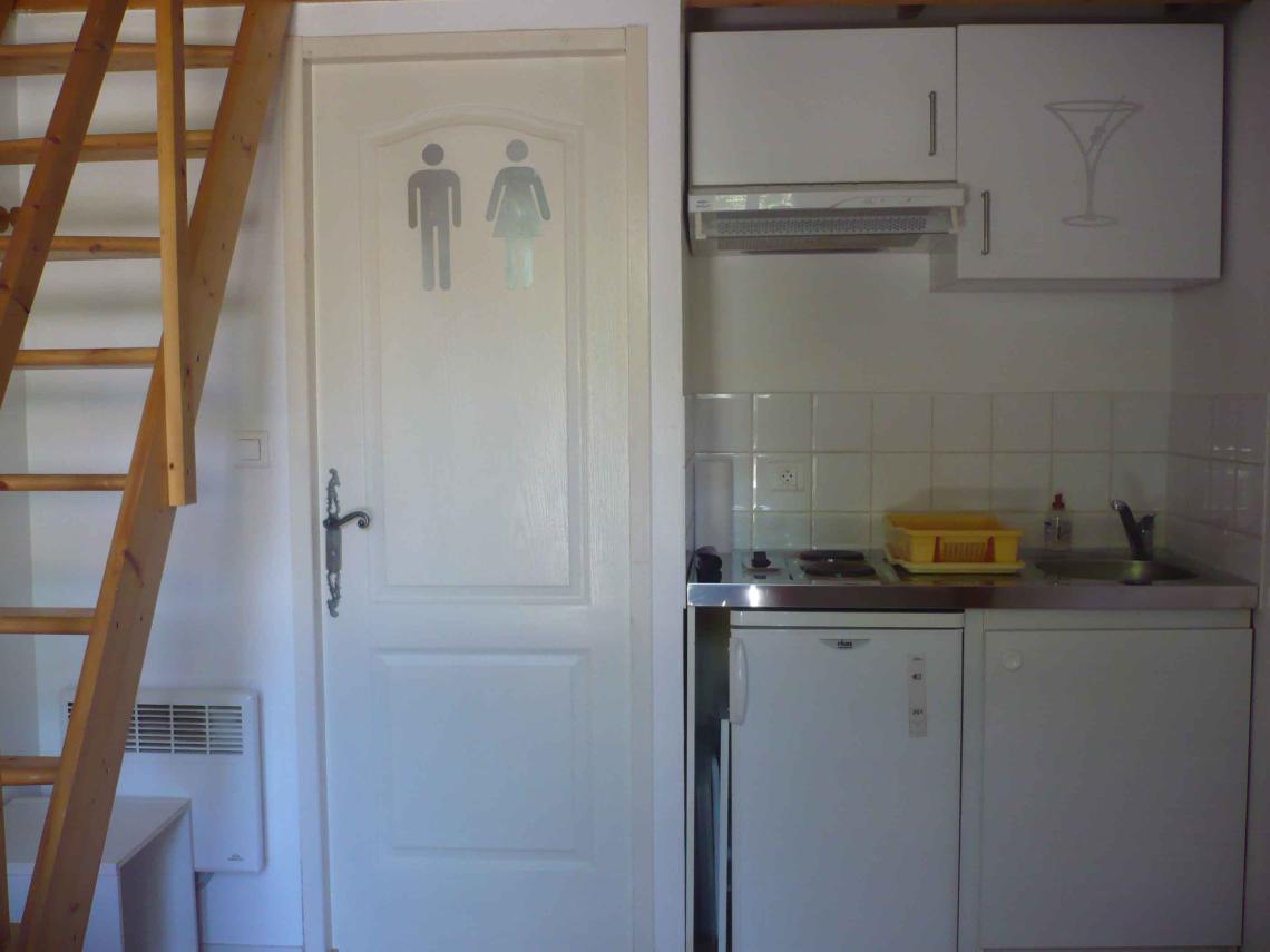 : kitchenette et porte de la salle d'eau